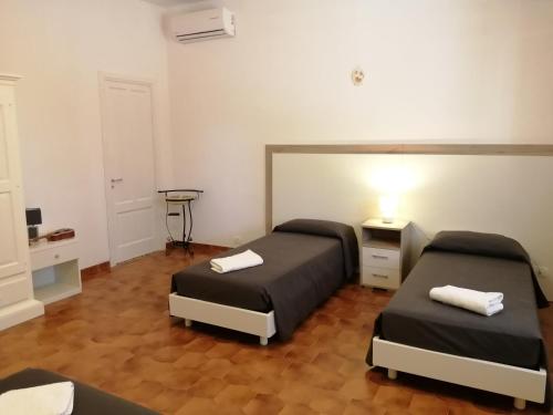 een kamer met 2 bedden en een tafel met een lamp bij Villa Graziella in Ostuni