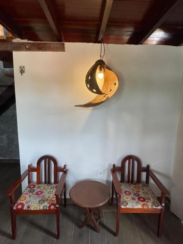 a room with two chairs and a table and a light at Vila Ypáwa 150 m centro 30 m praia lago verde in Alter do Chao