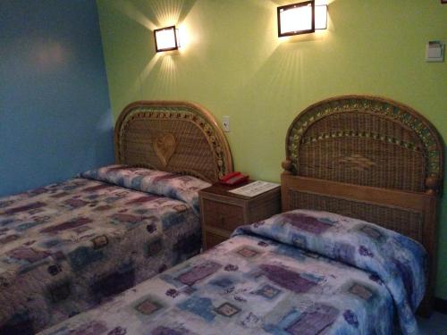 a bedroom with two beds and lights on the wall at RM Guest House in Dumaguete