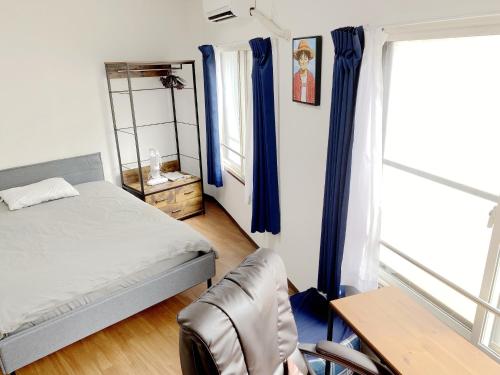 a bedroom with blue curtains and a bed and a table at SKYE HOME MINPAKU - Vacation STAY 11856 in Tokyo