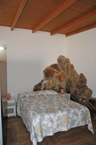 a bedroom with a bed and a stone wall at Casa Guanche in Cruce de Arinaga