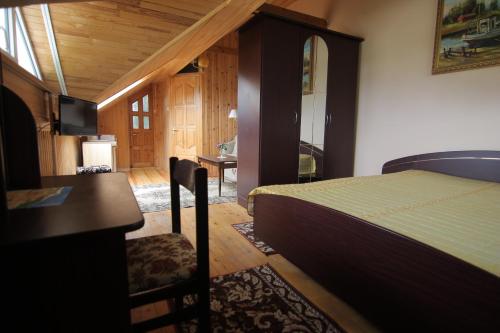 a bedroom with a bed and a desk and a television at Vila Saulute in Palanga
