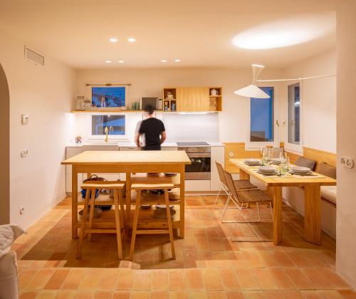 a man sitting at a kitchen table in a kitchen at Can Jove Cadaqués in Cadaqués
