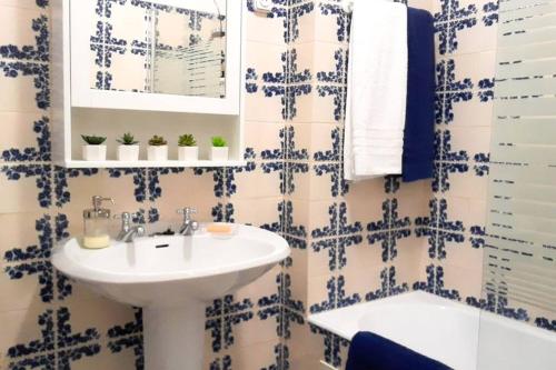 uma casa de banho com um lavatório e um espelho em Cozy beach front apartment em Portimão