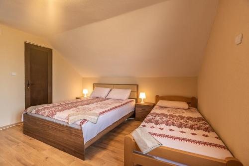 two beds in a small room with two lamps at Villa Vadian & Pool in Gevgelija