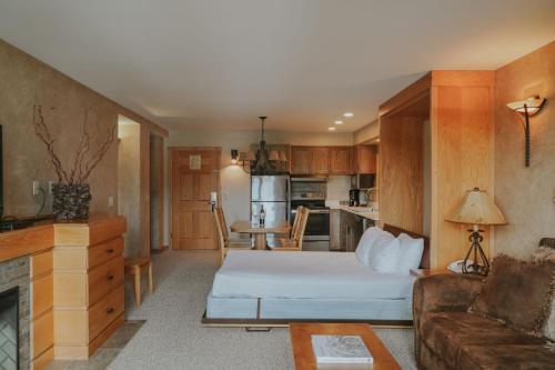 a room with a bed and a couch and a kitchen at Shoshone Condos at Big Sky Resort in Big Sky