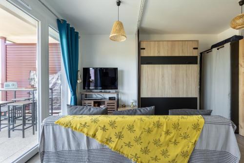 a bedroom with a bed with a yellow blanket at Provence, Studio climatisé, vue lac Spirou 400 metres, Avignon 15 mn in Monteux