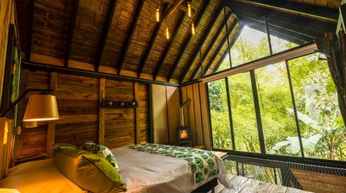 a bedroom with a bed and a large window at Glamping Lagos de Venecia in Santa Rosa de Cabal