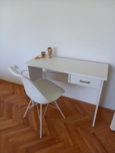 a white desk and a chair in a room at Centar apartman - gradski trg in Gornji Milanovac