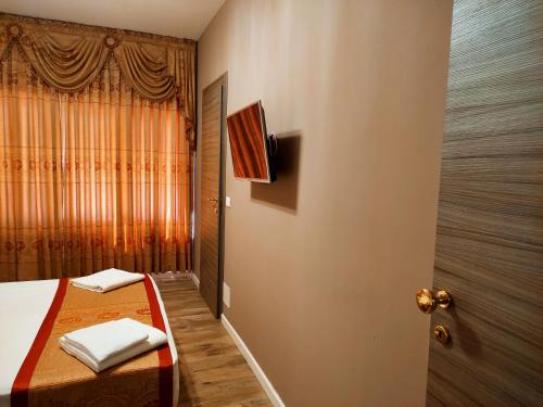 - une chambre avec un lit et une télévision murale dans l'établissement Hotel Venice Tour, à Mestre