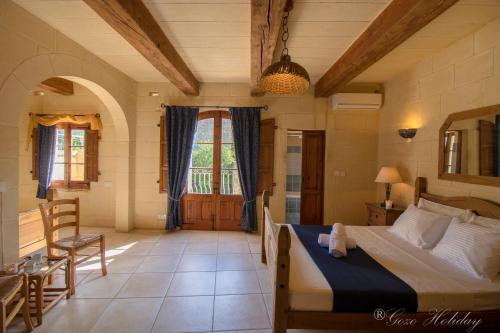 1 dormitorio con 1 cama, mesa y sillas en Ta Guzeppi Xaghra, en Xagħra
