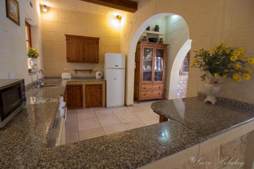eine Küche mit Kühlschrank und Arbeitsplatte in der Unterkunft Ta Guzeppi Xaghra in Xagħra