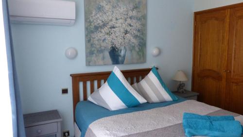 a bedroom with a bed with blue and white pillows at Appartement Stade Aime Giral in Perpignan