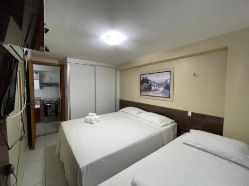 a hotel room with two beds and a television at Apt 219 in João Pessoa