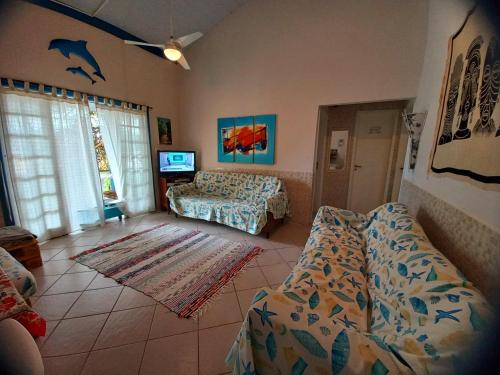 a living room with a couch and a bed at Casa Praia da Pinheira a 50m praia in Pinheira