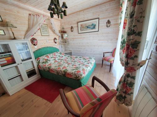 - une chambre avec un lit et une chaise dans l'établissement Villa "Le Mirage", à Cap-Ferret