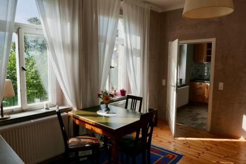 a dining room with a table and chairs and windows at Ferienwohnung ANDERE ZEITEN in Frankenberg