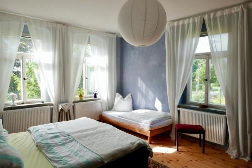 a bedroom with two beds and two windows at Ferienwohnung ANDERE ZEITEN in Frankenberg