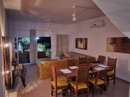 a dining room and living room with a table and chairs at Pé na Areia Praia Pitinga Casa13- Arraial d'Ajuda in Porto Seguro