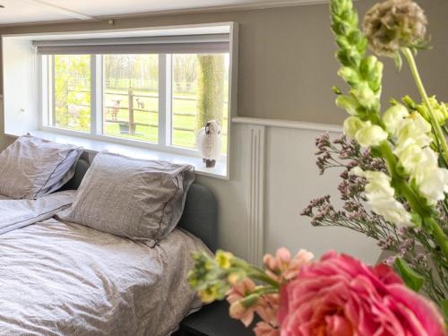 um quarto com uma cama, uma janela e flores em 4seasonshouse em Losser