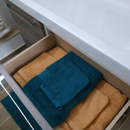 un tiroir rempli de serviettes sous un comptoir dans l'établissement Tosca - Appartement - Parking gratuit, à Orléans