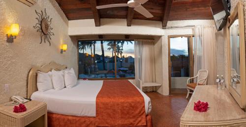 a hotel room with a bed and a balcony at Cabo Blanco Hotel and Marina in Barra de Navidad