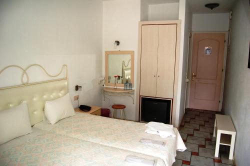 a bedroom with a large bed and a mirror at Hotel Villa Marie in Sivota