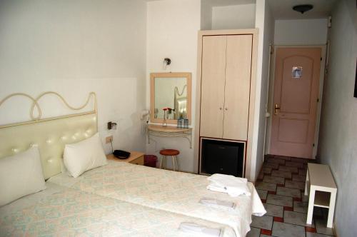 a bedroom with a large bed and a mirror at Hotel Villa Marie in Syvota