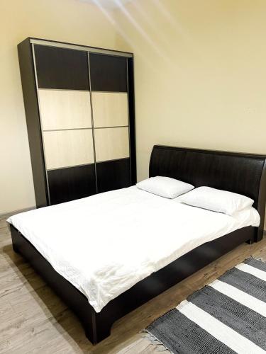 a bed with a black headboard in a room at Your apartment City Center Lviv in Lviv