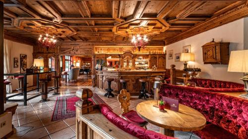 a living room with a couch and a bar at Romantik Hotel Santer in Dobbiaco