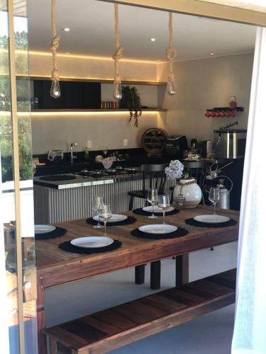 a kitchen with a table with wine glasses on it at Chalé lindo para toda família nas montanhas !!! in Domingos Martins