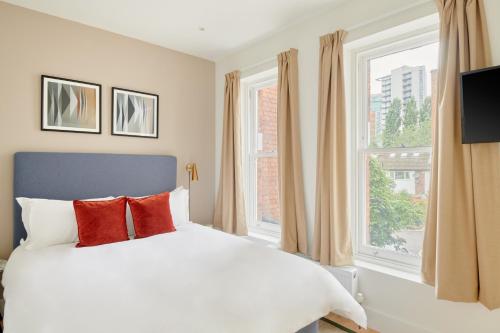 a bedroom with a white bed and a large window at Sonder The Prince, Vauxhall in London