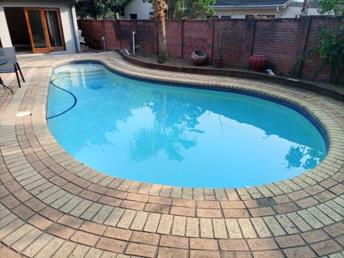 a swimming pool with blue water in a backyard at Nqabanqaba in Richards Bay
