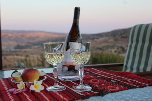 a table with two wine glasses and a bottle of wine at Infinity view villa in Nata