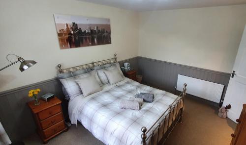 a bedroom with a bed with white sheets and a picture on the wall at Double room near Telford Town centre in Telford