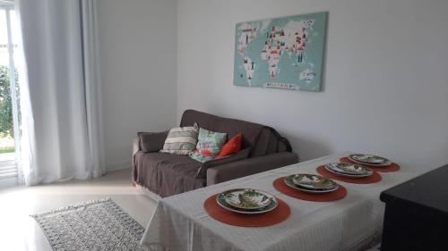 a living room with a table and a couch at Arraial do Cabo Golden Lake Residence frente a la laguna in Arraial do Cabo