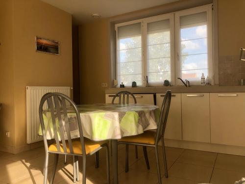 eine Küche mit einem Tisch, Stühlen und einem Waschbecken in der Unterkunft Appartement - Vakantiehuis Manou in De Panne