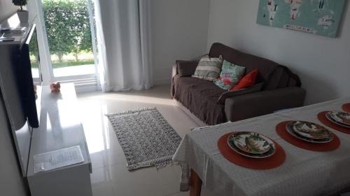 a living room with a couch and a table with plates on it at Arraial do Cabo Golden Lake Residence frente a la laguna in Arraial do Cabo