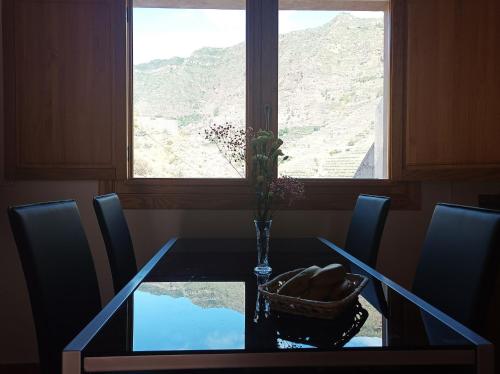 a dining room table with a vase of flowers and a window at CR las Nuevitas Tranquilidad y Descanso in Hermigua