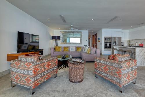 a living room with two chairs and a couch at Maxwell Residences at Indah in Puerto Vallarta