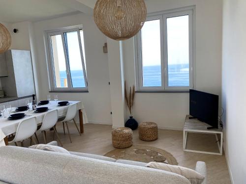 チェルヴォにあるIncanto sul mare con enorme terrazza e piscinaの白いソファとテーブルのあるリビングルーム