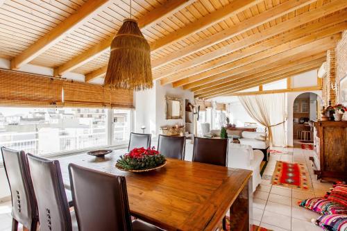 a dining room with a wooden table and chairs at Σοφίτα Μοναδικής Αύρας με Θέα & BBQ in Athens