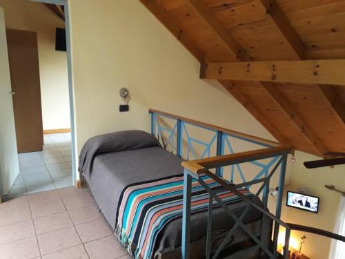 a bed in a room with a wooden ceiling at Cabañas Ruphay in Santa Rosa de Calamuchita