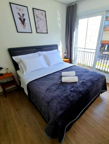 a bedroom with a large bed with two towels on it at Loft Gramado in Gramado