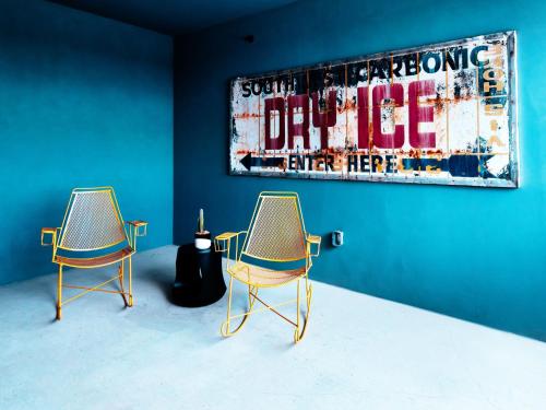 two chairs in a room with a painting on the wall at Hotel Dryce in Fort Worth