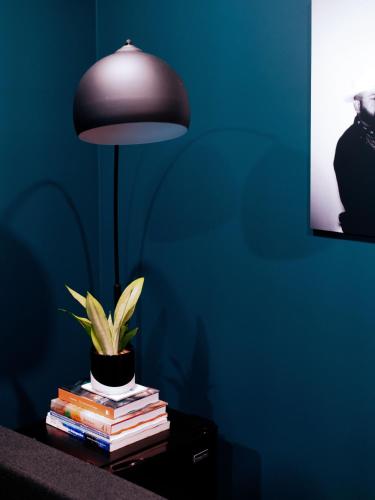 a lamp on a table with books and a potted plant at Hotel Dryce in Fort Worth