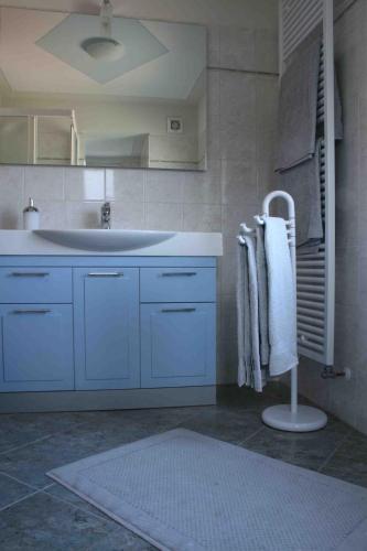 a bathroom with blue cabinets and a sink and a rug at B&B 21 in Cannobio