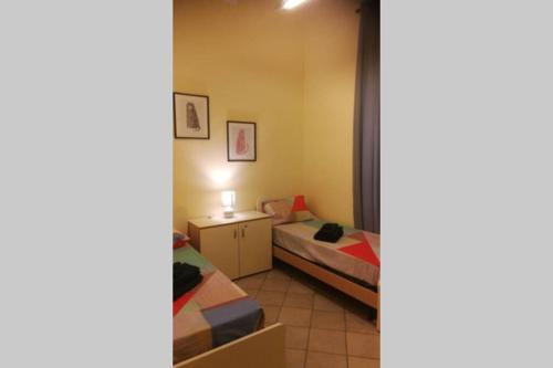 a small room with two beds and a table at Europa 37 in Messina