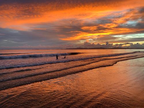 two people walking on the beach at sunset at Coto Center Homestay in Dao Co To