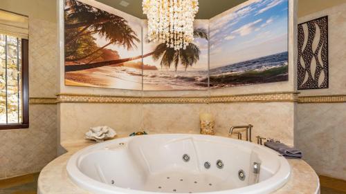 a bath tub in a bathroom with a large painting on the wall at Stunning beachfront Flamingo mansion with incomparable ocean setting in Playa Flamingo